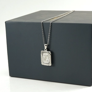 Detailed view of silver square pendant with letter Z engraving on a jewelry box