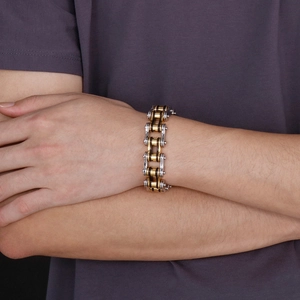 Close-up of men's two-tone stainless steel bike chain bracelet worn on a wrist