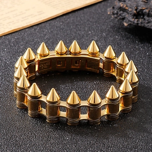 Macro detail of gold stainless steel bullet spike bracelet with engraved inner band