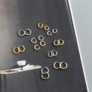 Macro detail of S925 sterling silver stamp on gold and silver zircon hoop earrings