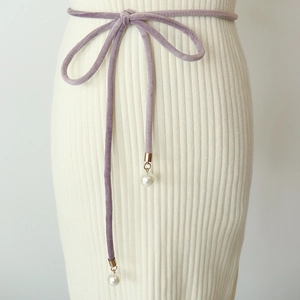 Detailed macro shot of purple velvet tie waist belt with decorative pearl pendants