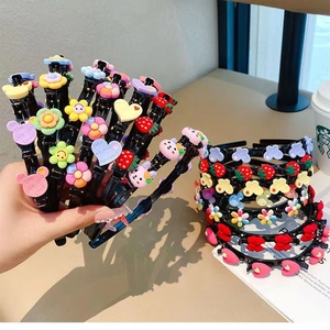 Detail showing various resin charms like flowers, strawberries and bears on children hair clips