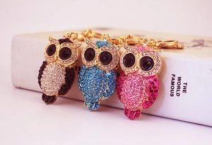 Macro shot of owl keychains with colorful rhinestones in brown, blue and pink