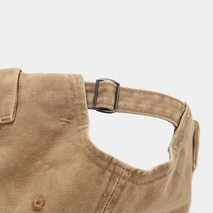 Détail de la sangle réglable en coton kaki avec boucle métallique sur le bonnet vintage