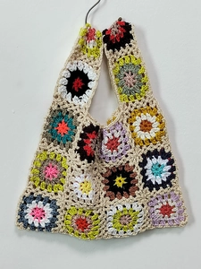 Detailed knit texture of handmade colorful crochet tote bag with floral patterns