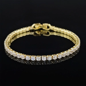 Close-up detail of golden tennis bracelet with sparkling cubic zirconia stones and box clasp