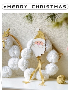 Detail of plush Christmas wreath with white pom-poms and hand-painted wooden Santa Claus