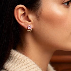 Gros plan d'une boucle d'oreille fleur en zircon rose plaqué or sur un mannequin