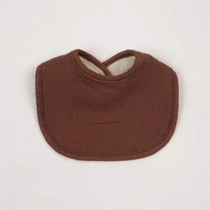 Detail of baby cotton bib featuring absorbent brown gauze and soft fleece lining
