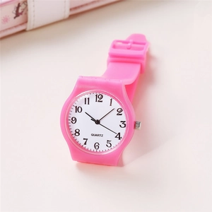 Close-up of pink silicone watch featuring white dial with clear black numerals and quartz logo