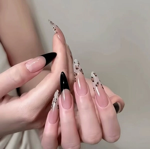Long almond press-on nails with leopard print and black french tip design in nude pink