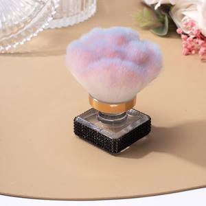 Primer plano de brocha de maquillaje con diamantes y cerdas degradadas rosa y azul