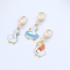 Detailed view of three cartoon duck keychains with stethoscope, swim ring and backpack charms