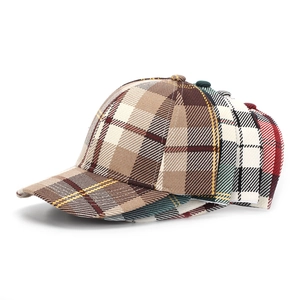 Detailed view of plaid pattern baseball caps in brown green and red checkered fabric
