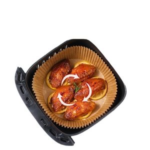Round disposable air fryer liners with roasted chicken wings in a hot air fryer
