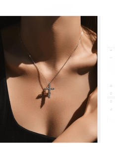 Macro shot of s925 silver cross pendant with moissanite pavé on a model's neck