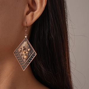 Ethnic bohemian hollow diamond-shaped earrings with coconut shell beads on a model