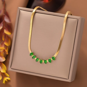 Gold herringbone necklace with seven green teardrop gemstones on a brown jewelry box