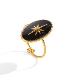 Detailed macro view of black enamel oval ring with gold star and adjustable open band