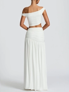 White two-piece long dress set featuring a chic one-shoulder crop top and ruched maxi skirt