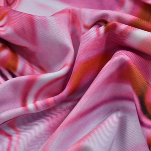 Détail macro du tissu à imprimé marbre rose avec texture soyeuse et drapé élégant
