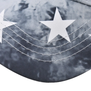 Close-up of baseball cap brim featuring white star print and grey tie-dye cotton fabric