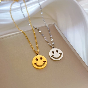 Minimalistische Smiley-Anhänger-Halsketten in Gold und Silber auf Seidenhintergrund