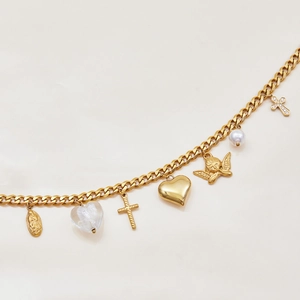 Close-up of gold layered necklace with Virgin Mary, cross, angel and heart charms
