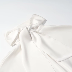 Gros plan sur la robe en satin blanc avec un nœud papillon géant élégant et soyeux