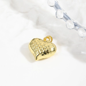 Macro shot of 18k gold plated hollow heart pendant with quilted texture and ring