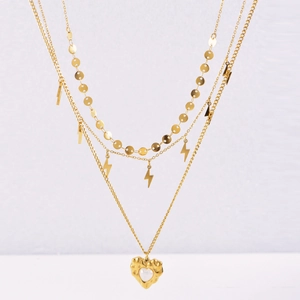 Close-up of gold layered necklace with lightning bolts and heart-shaped pendant detail