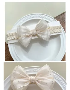Macro detail of infant lace headband featuring large cream bow with silver polka dots