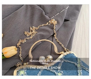 Detail of vintage blue denim shell bag with pearl clasp and rhinestone metal handle