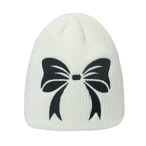 White ribbed knit beanie hat featuring a black embroidered bow for women winter warmth