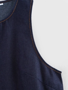 Detail of dark blue denim fabric with contrast orange stitching and high-quality texture