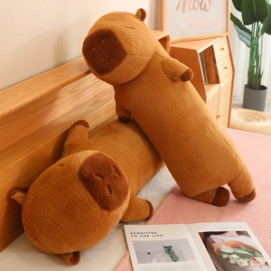 Cozy long capybara plush pillows on a bed, showing the soft brown fabric and cute details