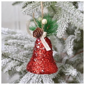 Cloche de Noël rouge scintillante avec pommes de pin sur branche enneigée