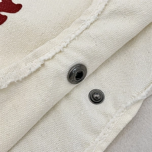 Vue détaillée du bouton-pression en métal vintage et texture tissée du sac en toile