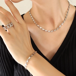 Silver jewelry set with chain-style necklace bracelet and ring on a female model