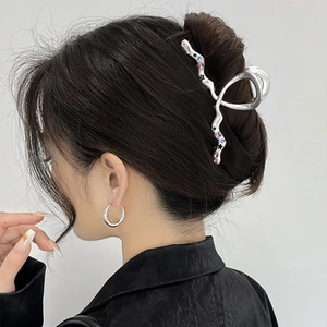 Detail of silver Y2K metal shark hair claw clip with colorful rhinestones on hair