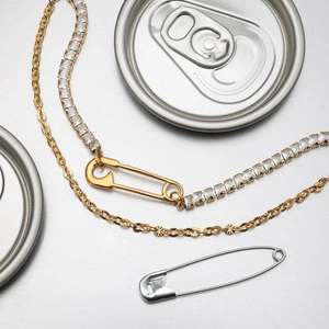 Détail du bracelet chaîne trombone en or 18 carats avec pendentif épingle à nourrice en zircon