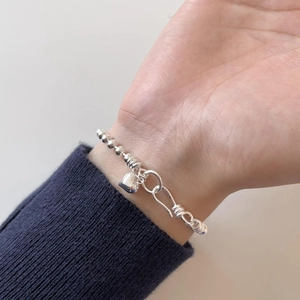Close-up of S925 sterling silver beaded bracelet featuring a heart charm and spiral clasp