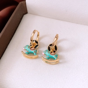 Detailed close-up of 18K gold plated hoop earrings with blue enamel rocking horse charms