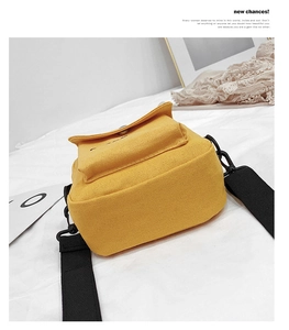 Detail of yellow canvas crossbody bag showing durable fabric texture and side thickness