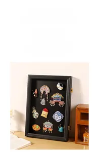 Detail of a black wooden frame for enamel pins with metal hinges and secure lock