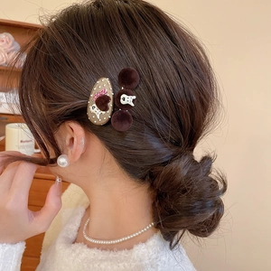 Close-up of brown flocked dog and bear hair clips worn on a bun hairstyle detail