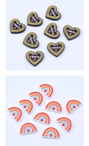 Detail of PVC shoe charms featuring heart-shaped pencil and rainbow teach motifs