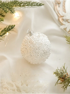 Detail of 8cm white Christmas ball with elegant pearls and sequins on a festive background