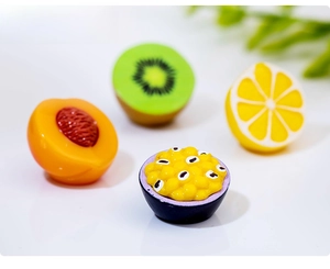 Macro detail of miniature resin fruit models including kiwi, peach, lemon, and passion fruit