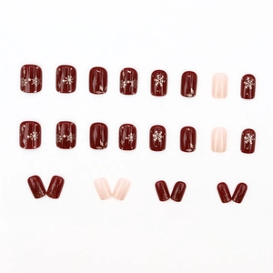 Deep red and pink glitter press-on nails with white snowflakes and golden glitter accents